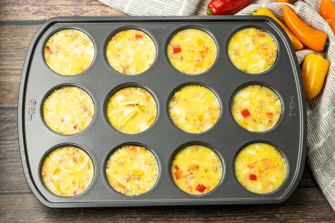 muffin tin pan full of scrambled bacon egg mixture