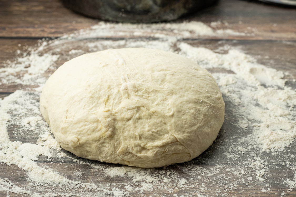 form no knead bread dough into a ball on a floured surface