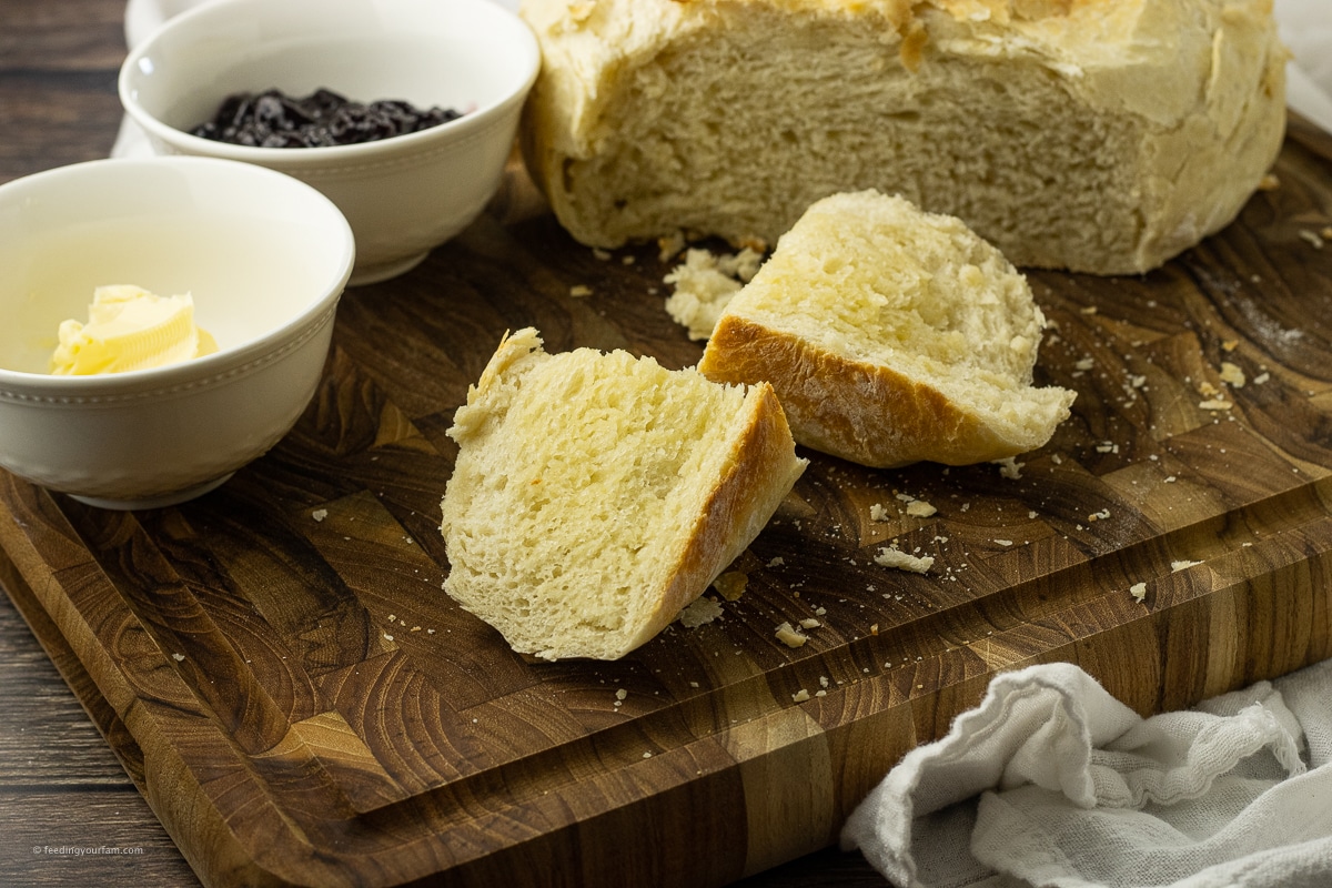 no knead dutch oven bread sliced on a wooden cutting board
