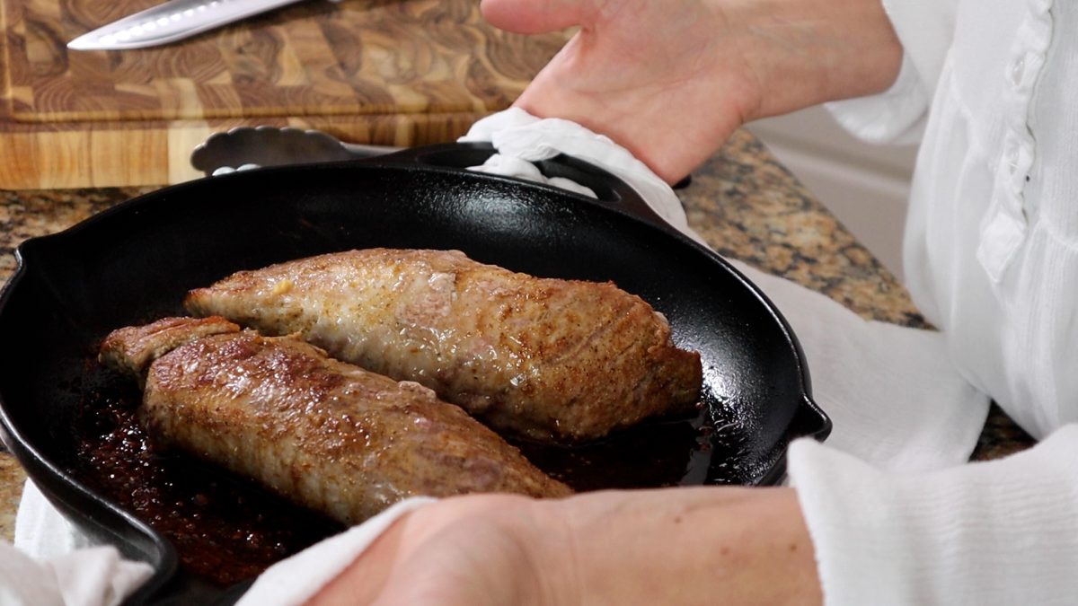 two pork tenderloins in a cast iron pan