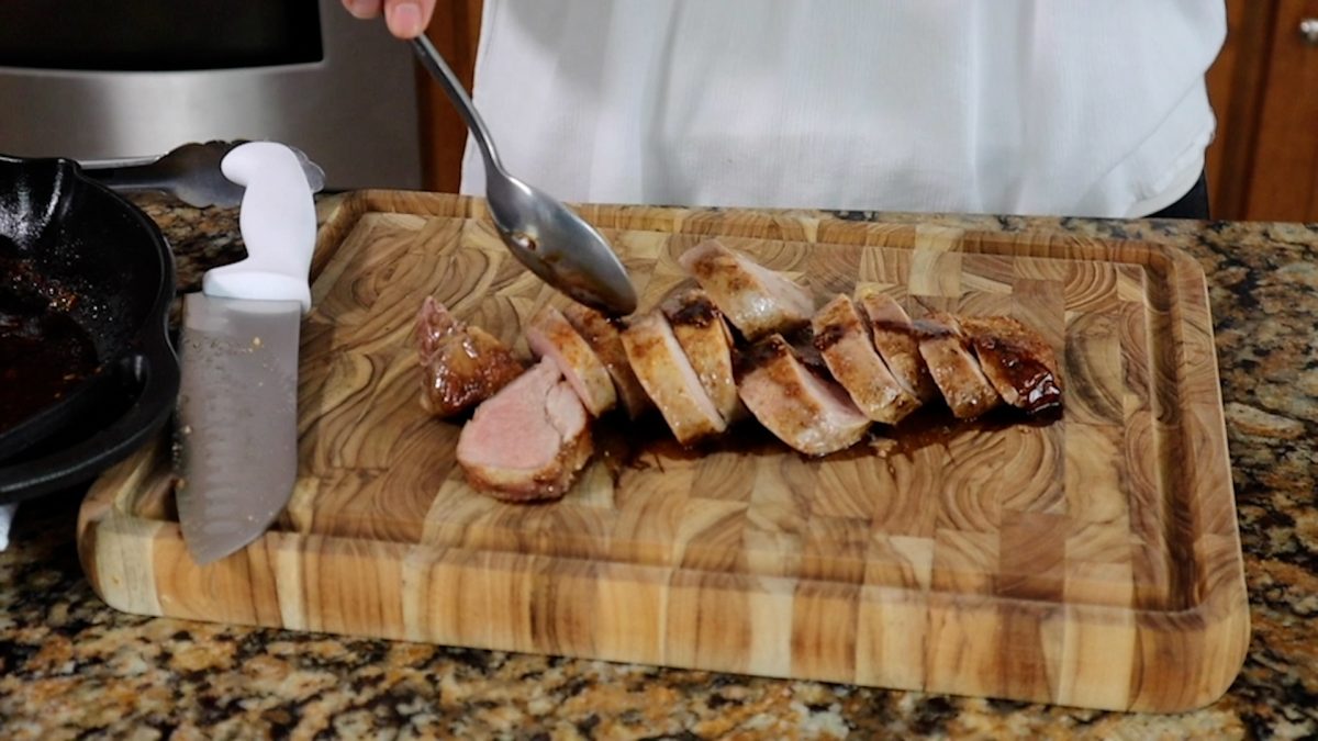 drizzling balsamic glaze over sliced pork tenderloin