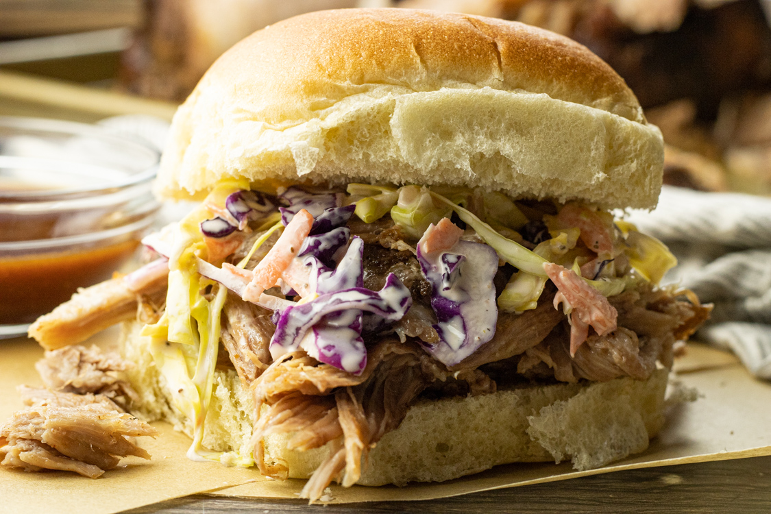 pulled pork sandwich topped with coleslaw salad
