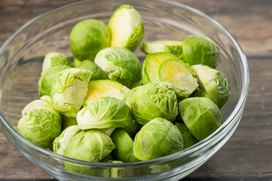 sliced, green brussel sprouts in a glass bowl