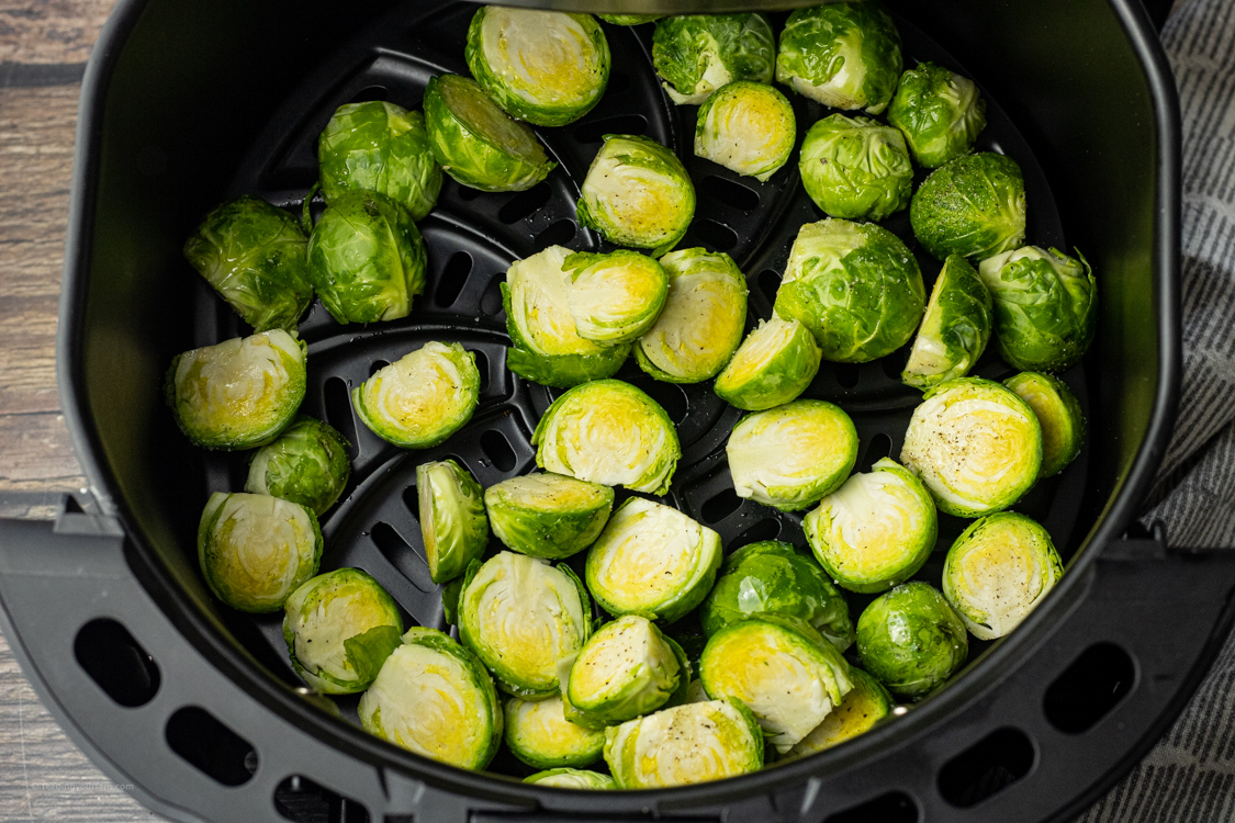 uncooked brussel sprouts in an air fryer basket