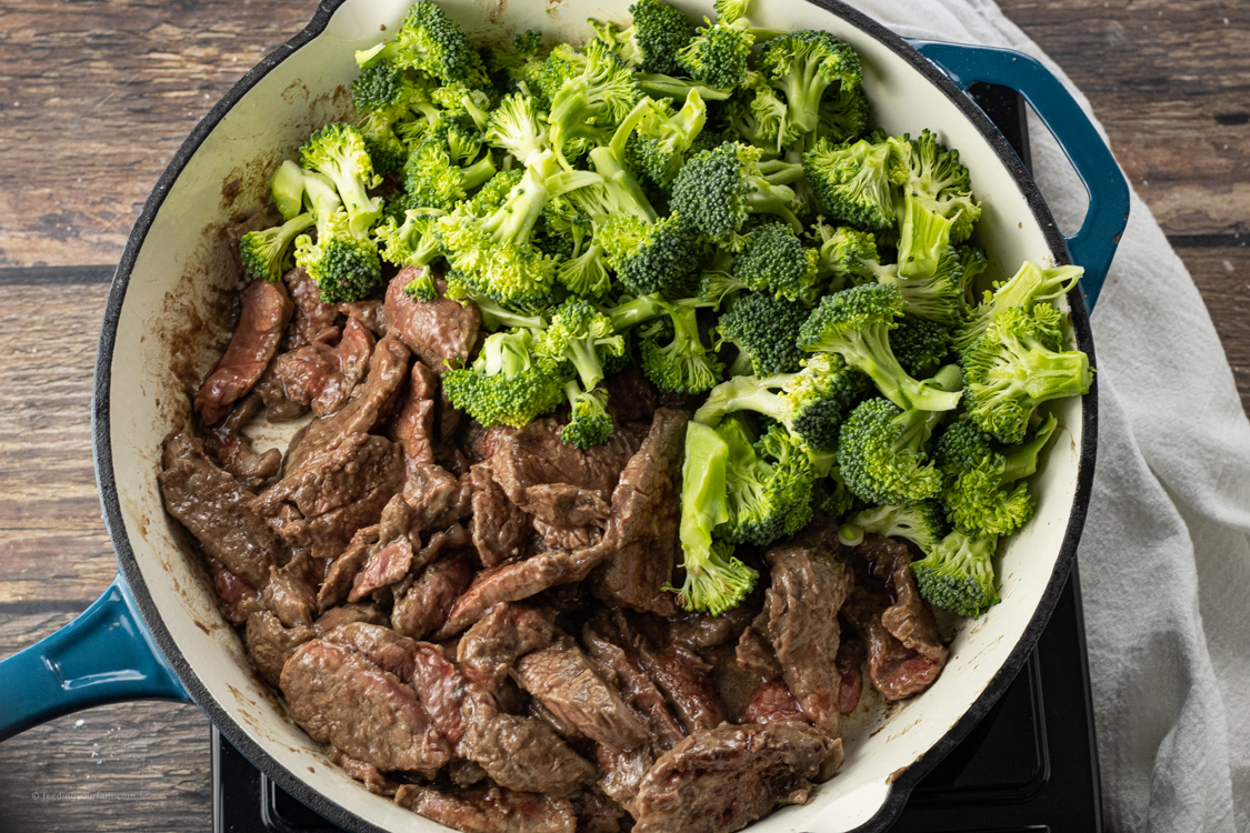 sliced steak and broccoli in a large pan