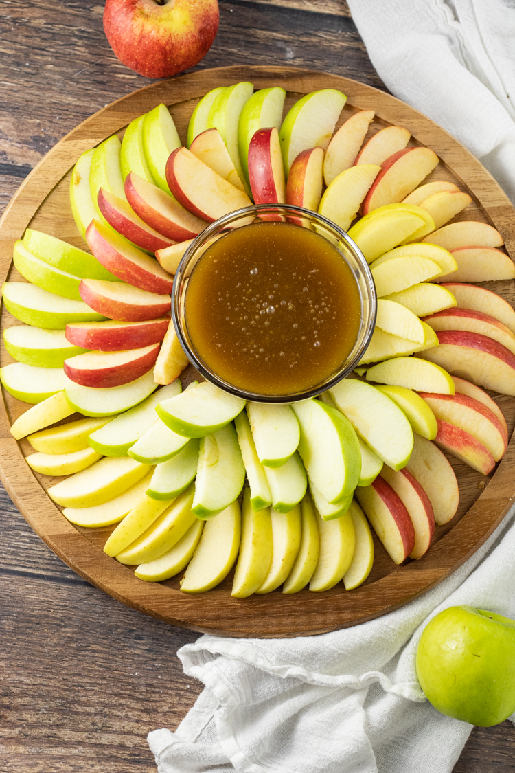 sliced apples surrounding dipping sauce made of caramel