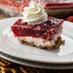pretzel jello salad layered with pretzels on the bottom, cream cheese in the middle and raspberry jello on top