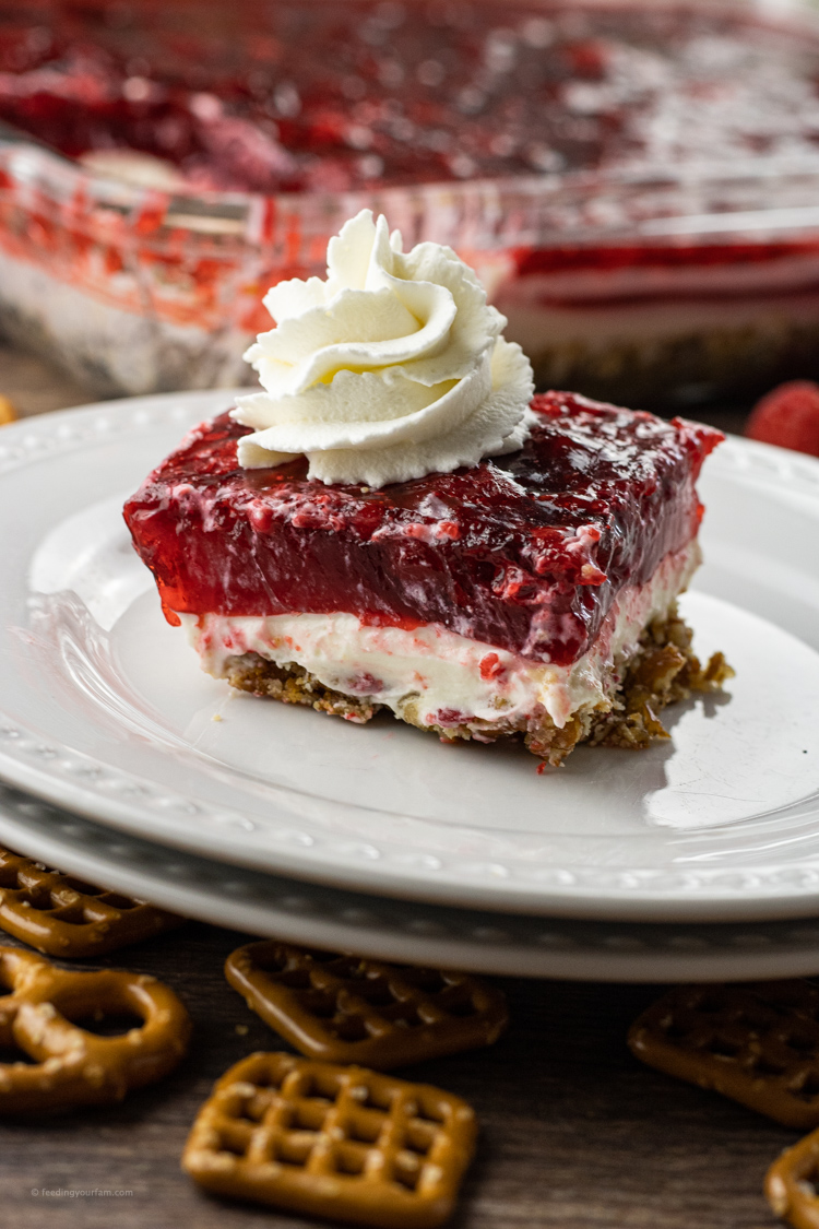 pretzel jello salad layered with pretzels on the bottom, cream cheese in the middle and raspberry jello on top