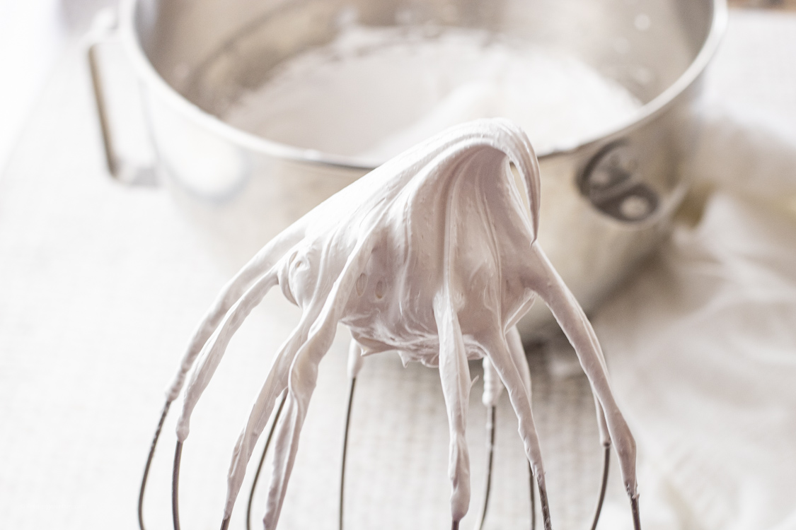 stiff meringue egg whites on a whisk