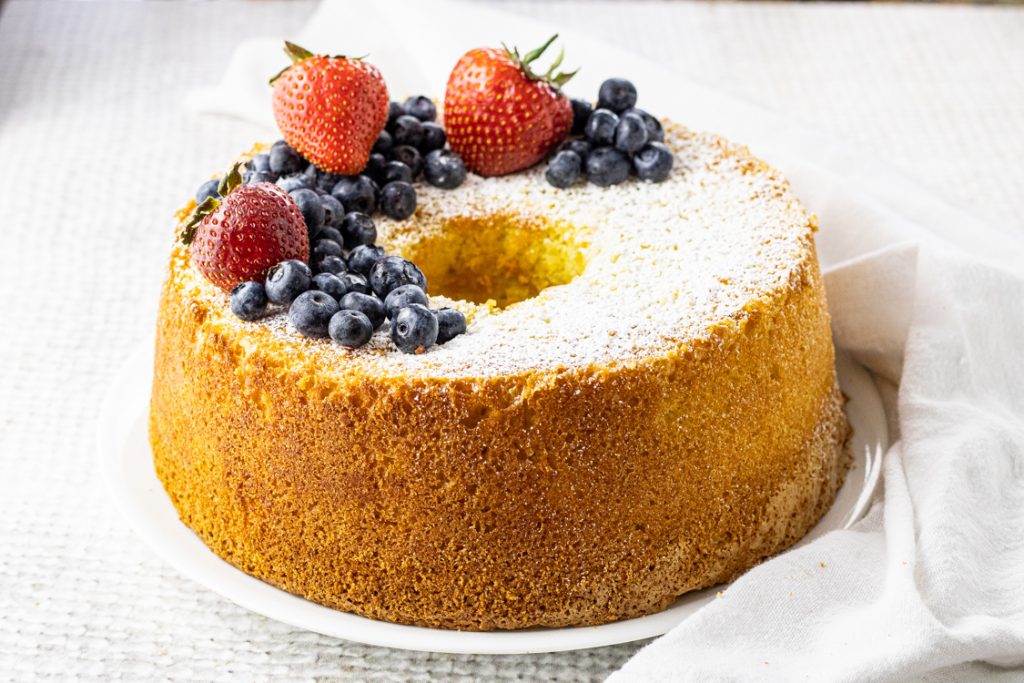chiffon cake topped with powdered sugar, blueberries and strawberries
