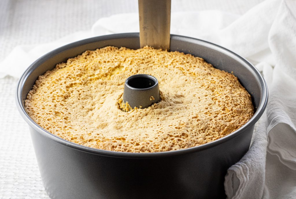 removing a chiffon cake from a tube pan with a knife