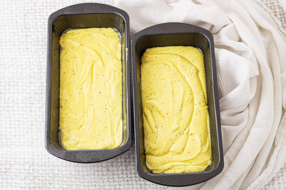 two loaf pans filled with yellow batter for lemon bread