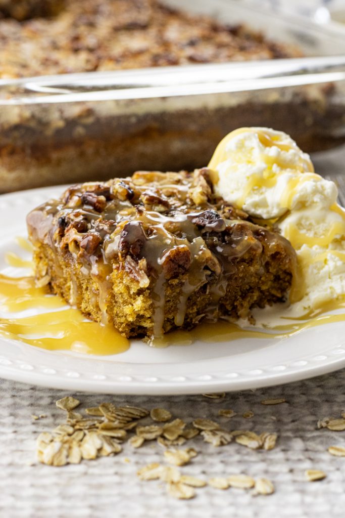 slice of oatmeal cake topped with coconut and pecans with vanilla ice