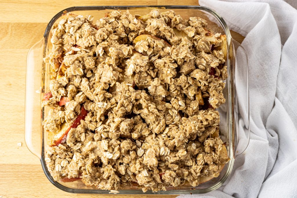 oat topping on top of apples in a glass pan