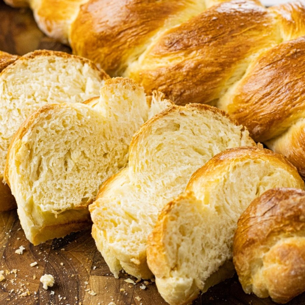 challah bread sliced on a wooden cutting board