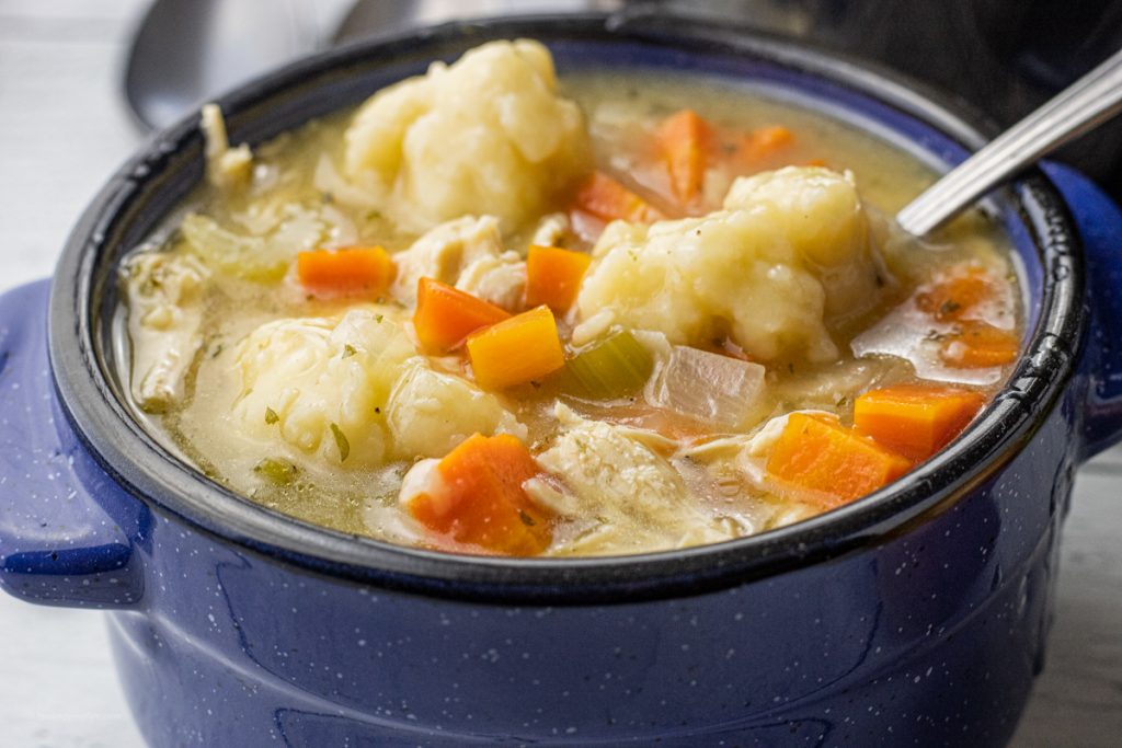 chicken and dumplings soup in a blue soup bowl