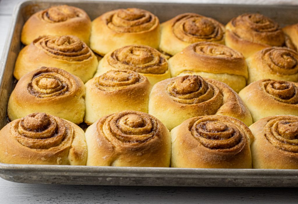unfrosted cinnamon rolls on a baking sheet