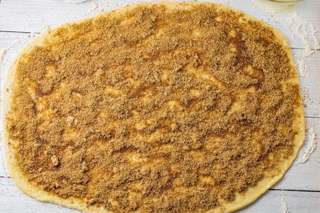 dough rolled out and topped with cinnamon and brown sugar