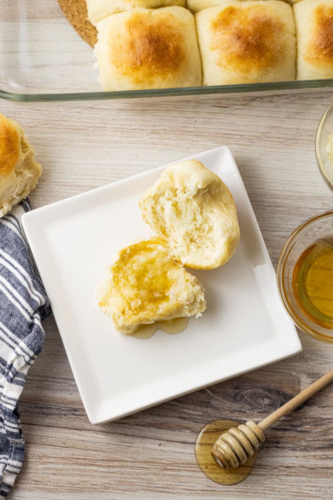dinner rolls opened and topped with honey and butter