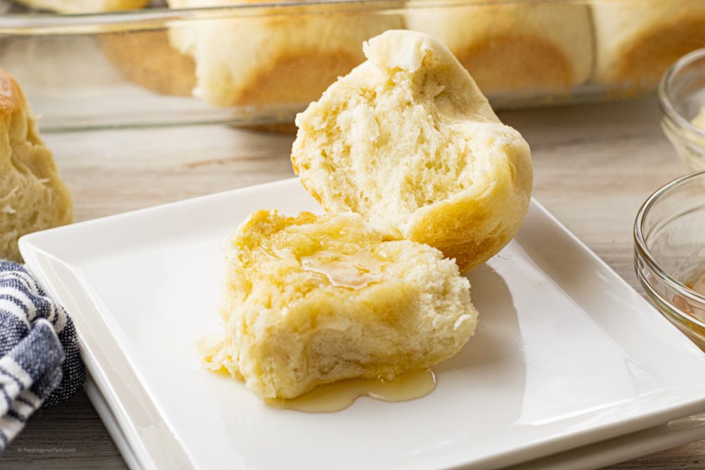 homemade roll sliced in half and topped with butter and honey