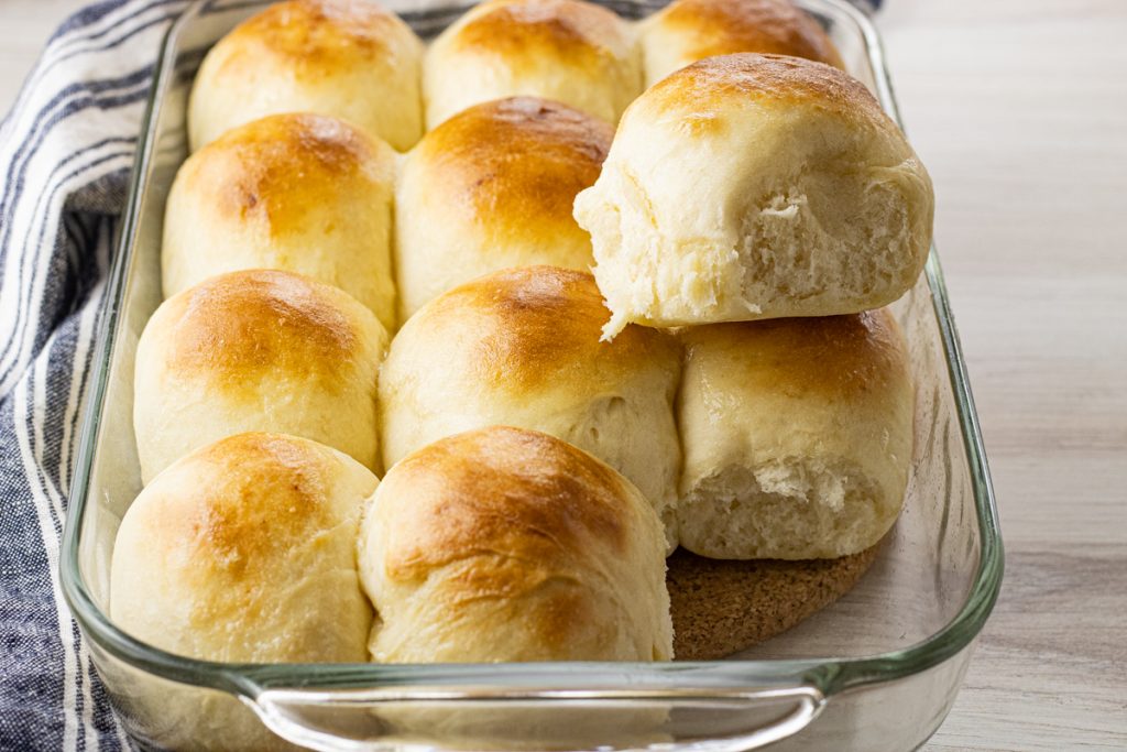 glass pan full of golden brown, homemade dinner rolls