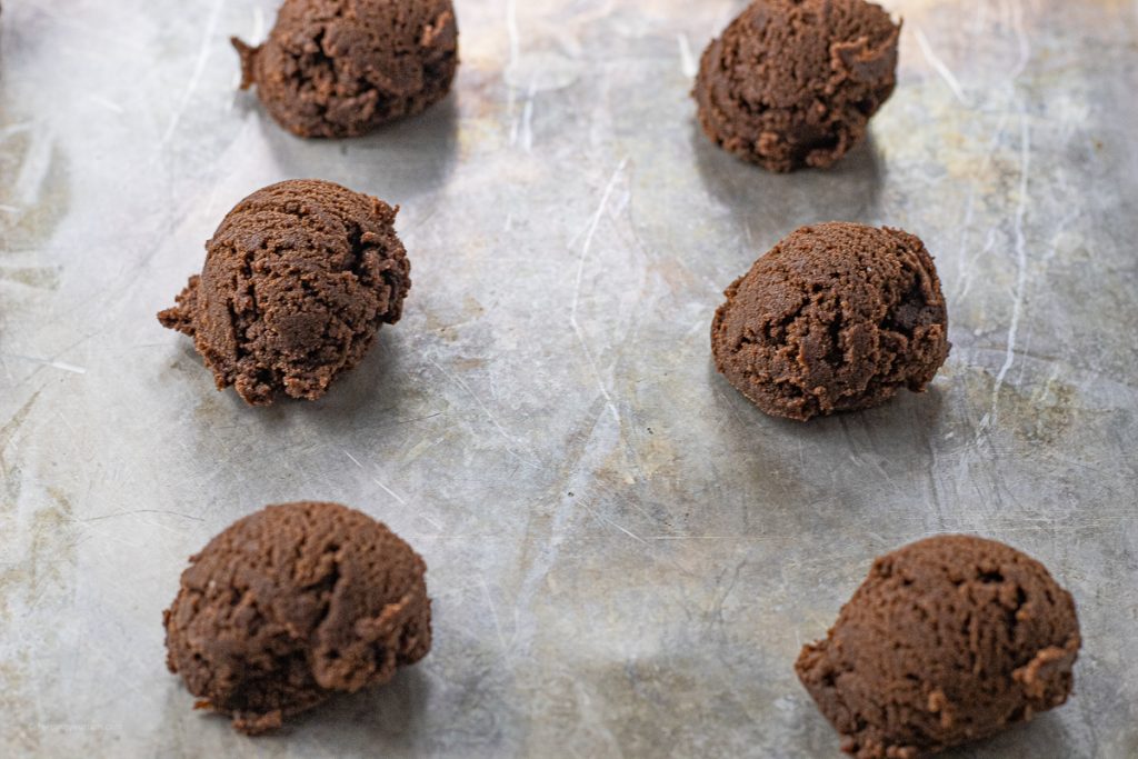 chocolate cookie dough balls on a baking sheet