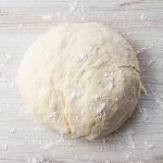 pizza dough ball on a marble surface