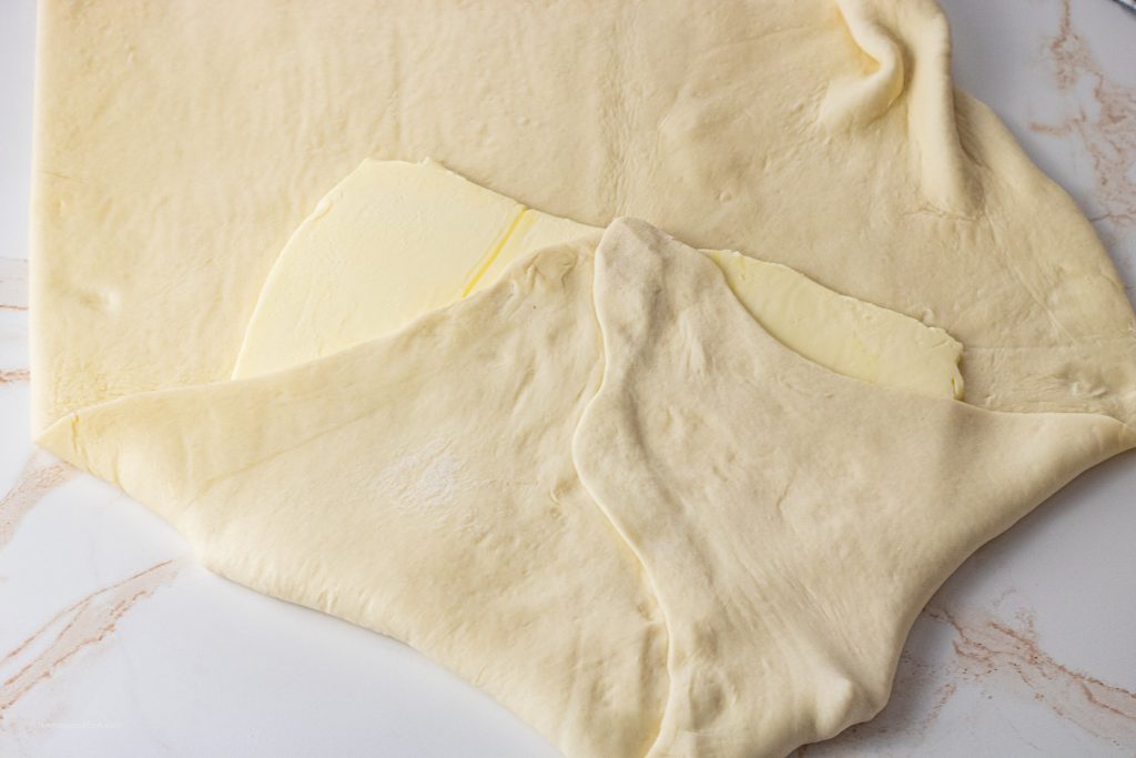 wrapping dough around a slab of butter