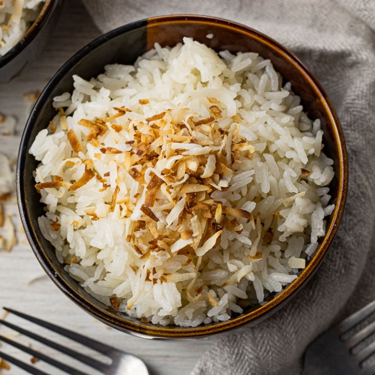 brown bowl filled with rice topped with toasted coconut