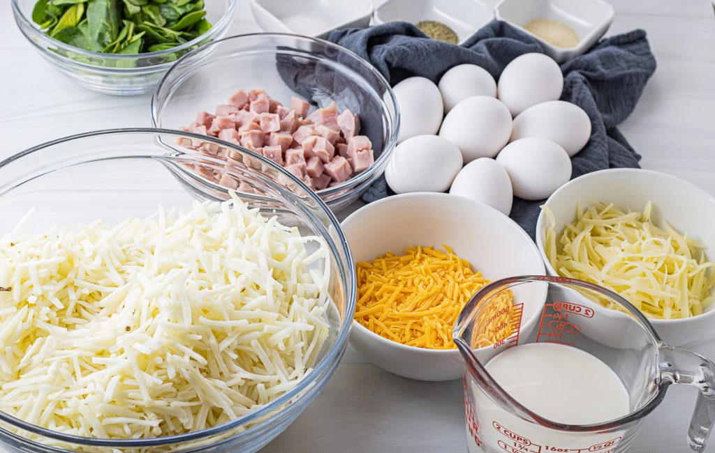 grated swiss cheese, cheddar cheese, eggs, milk, salt, black pepper, onion powder, spinach, ham, hash browns