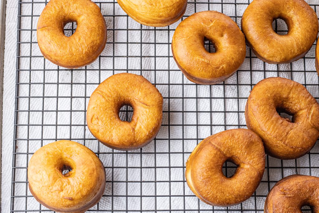 golden brown fried donuts on a cooling rack