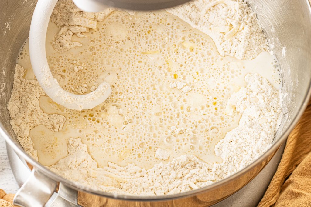 metal mixing bowl with flour, milk, and water