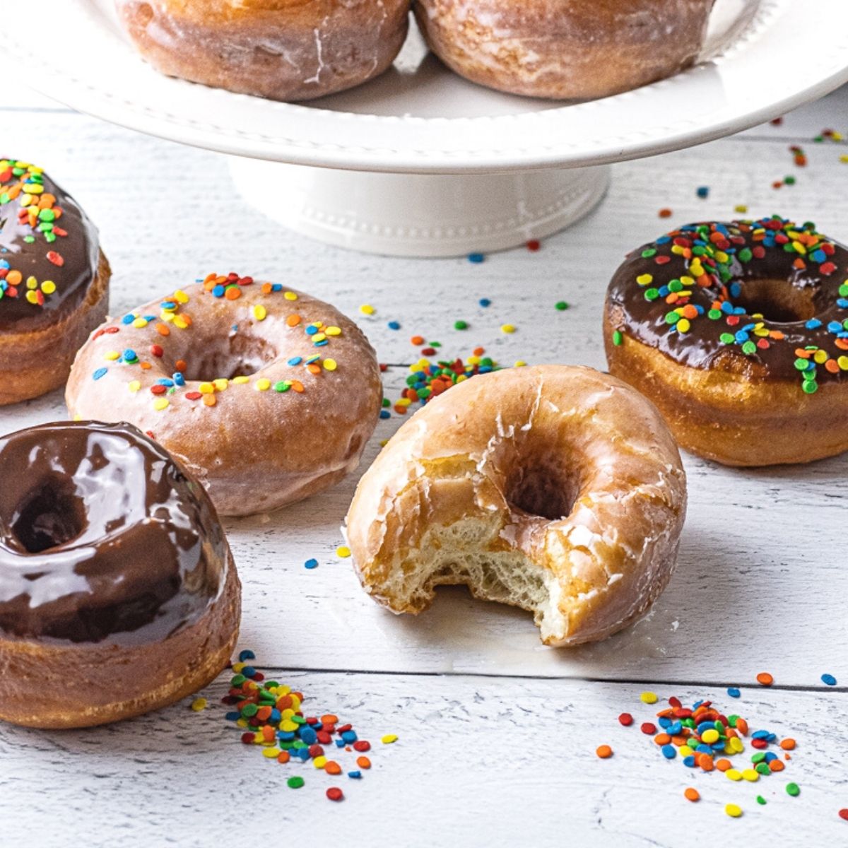 glazed and chocolate donuts one with a bite out of it