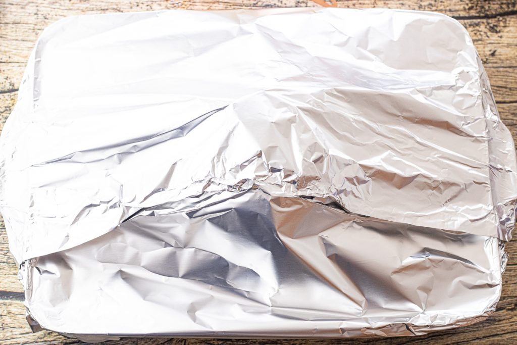 ham in a roasting pan covered with foil