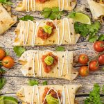 baked chimichangas topped with salsa, guacamole and sour cream