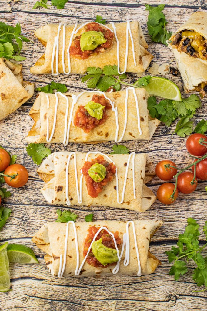 baked chimichangas topped with salsa, guacamole and sour cream