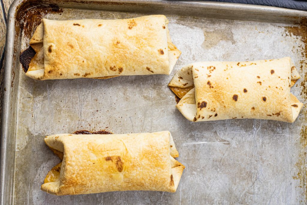 baked chimichangas on a baking sheet