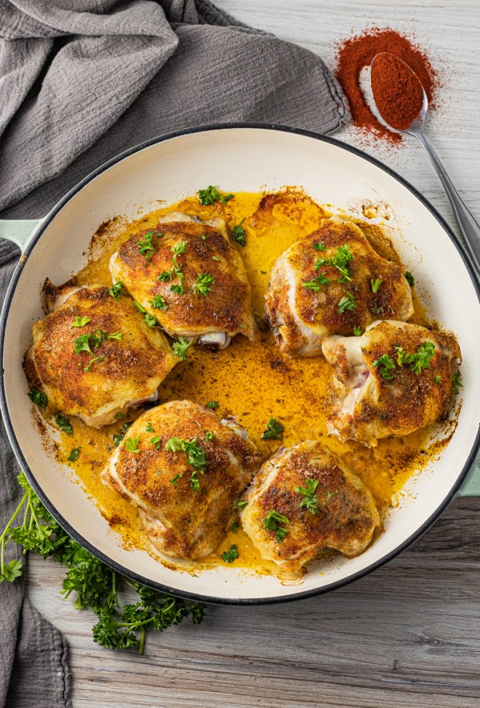6 baked chicken thighs in an enamel cast iron pan