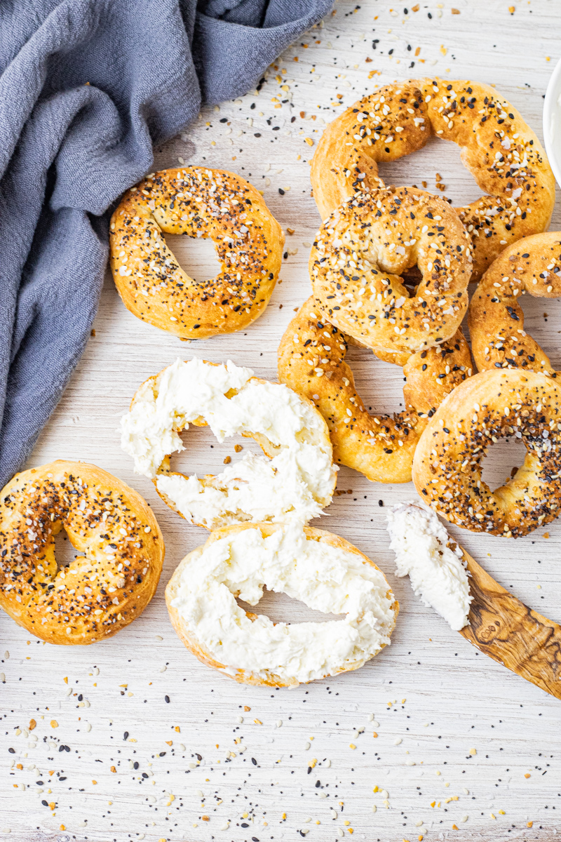 everything bagels one sliced into two halves and topped with cream cheese