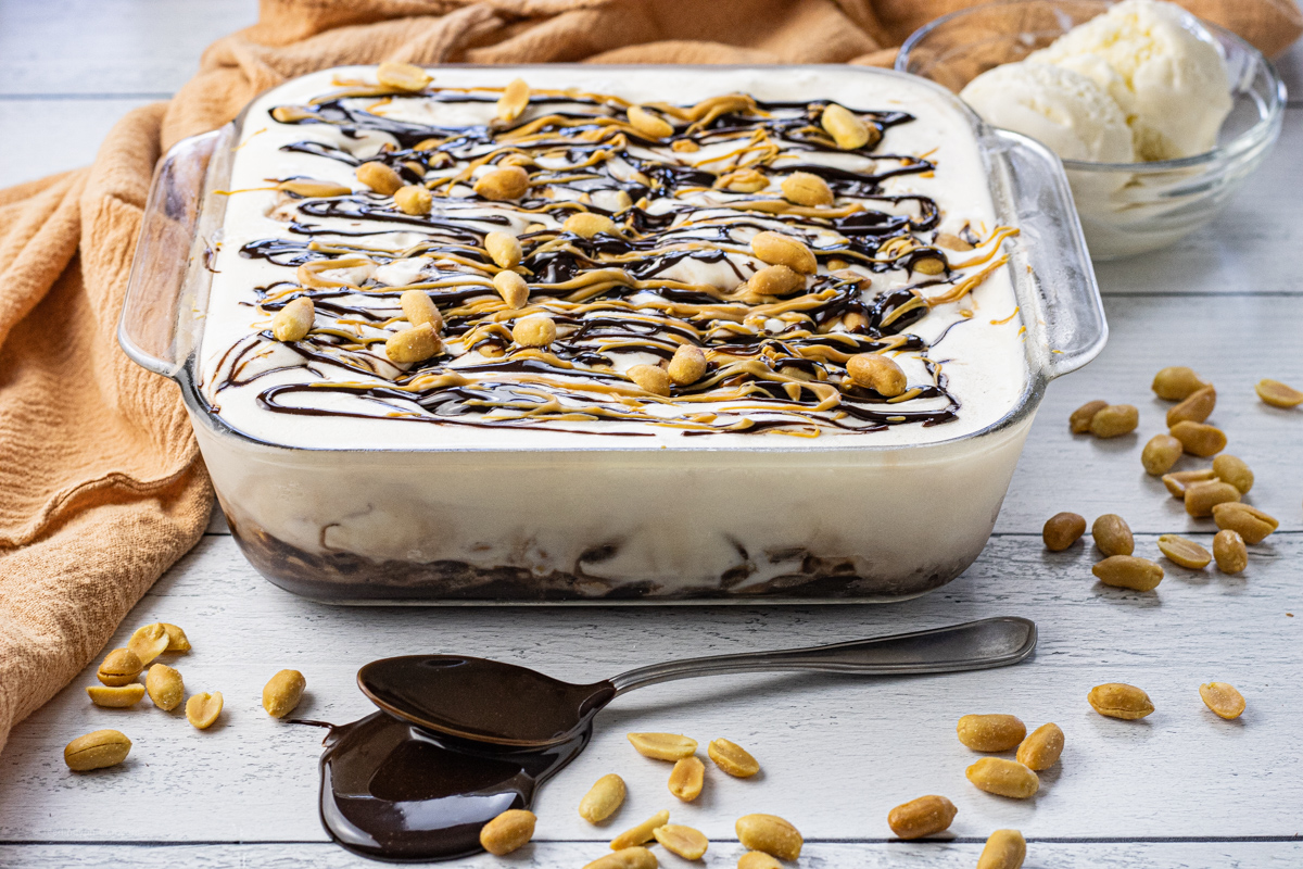 ice cream cake topped with peanuts, hot fudge and peanut butter