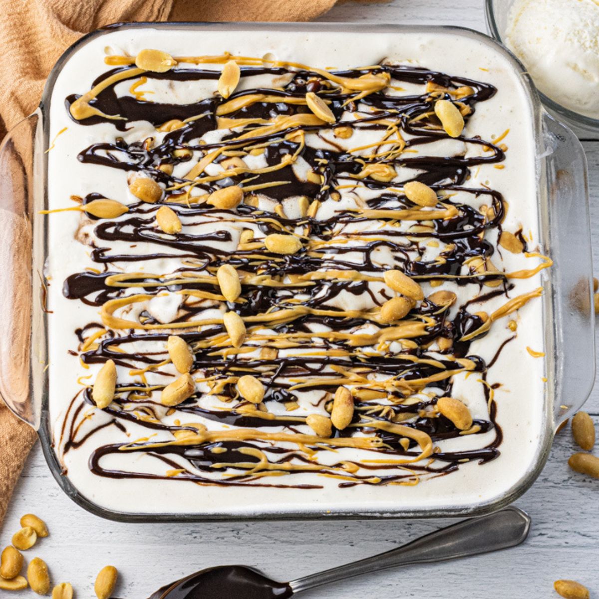 ice cream cake topped with hot fudge and peanuts