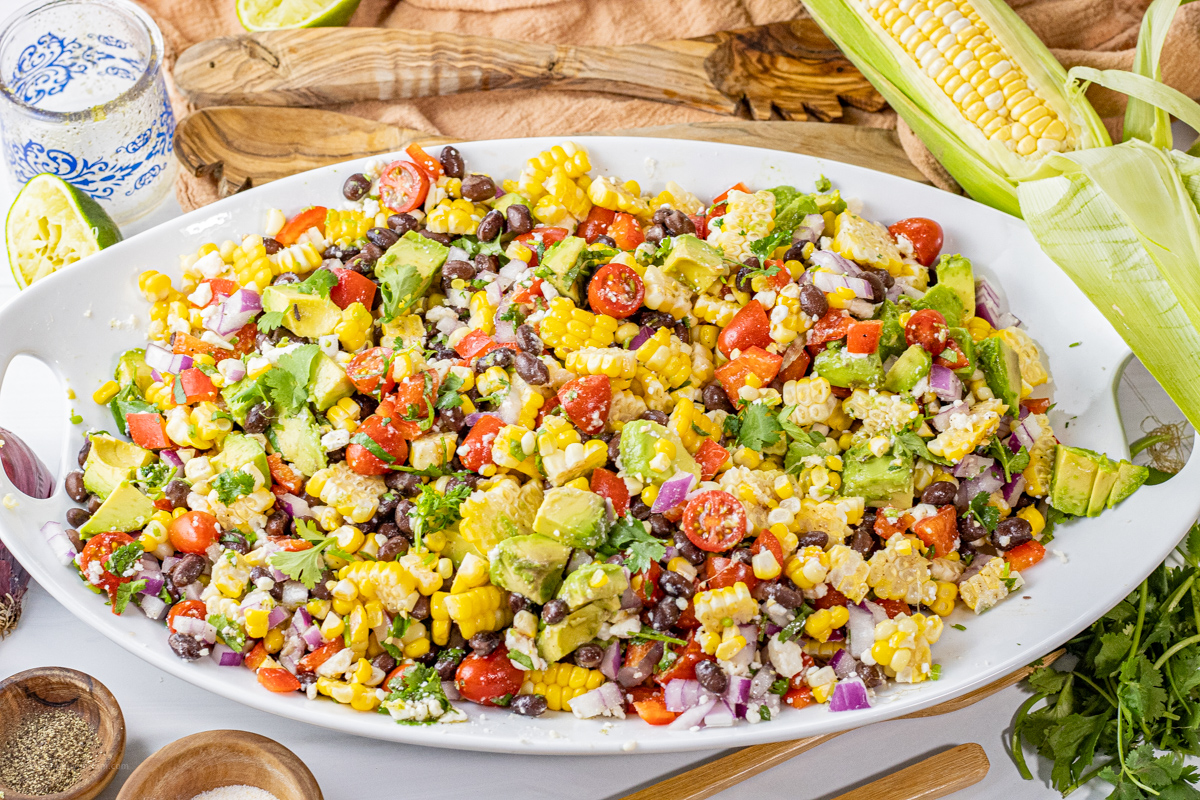 corn, avocado salad on a white plate