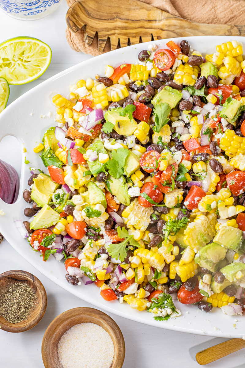 black beans, corn, tomato salad on a white platter
