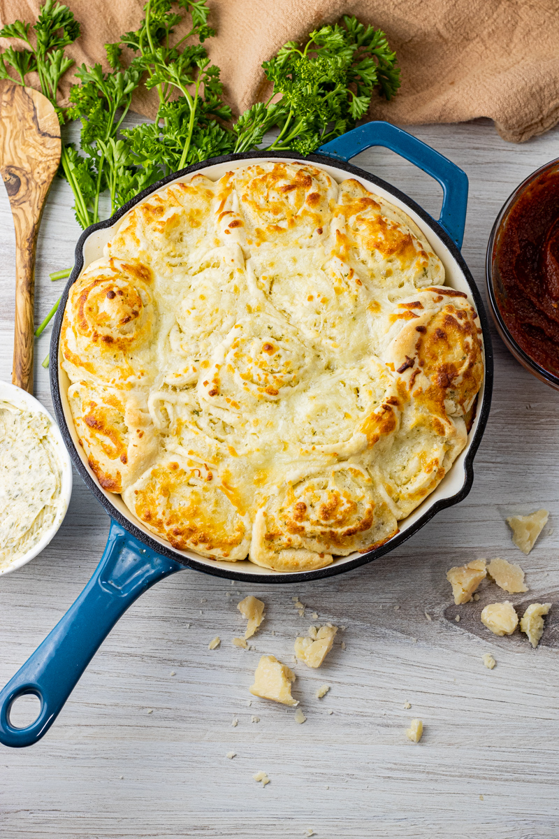 blue cast iron enamel pan filled with garlic cheese rolls