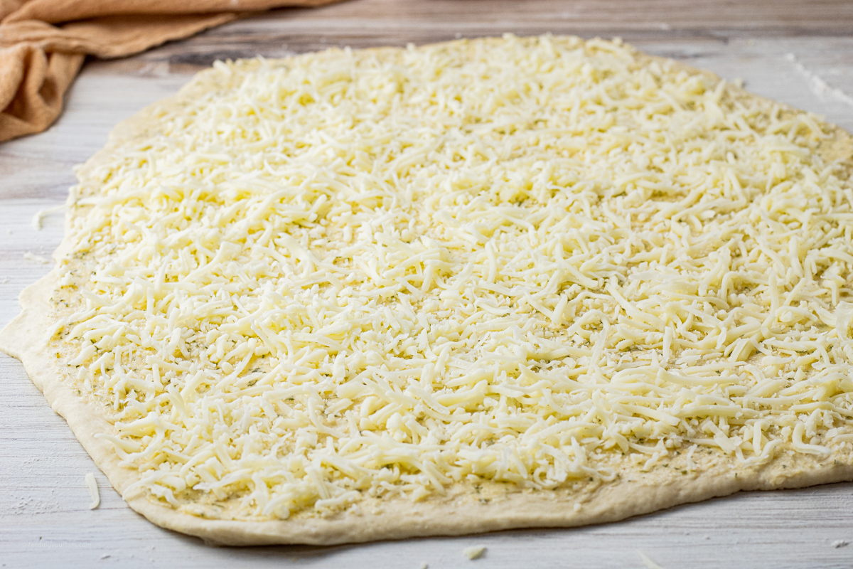 rolled out dough topped with garlic butter and mozzarella cheese