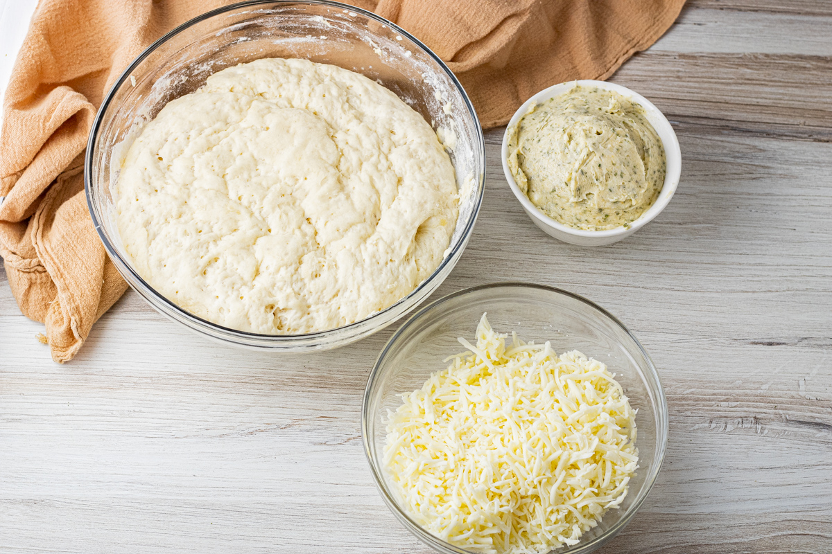 garlic butter, roll dough and shredded mozzarella cheese in glass bowls