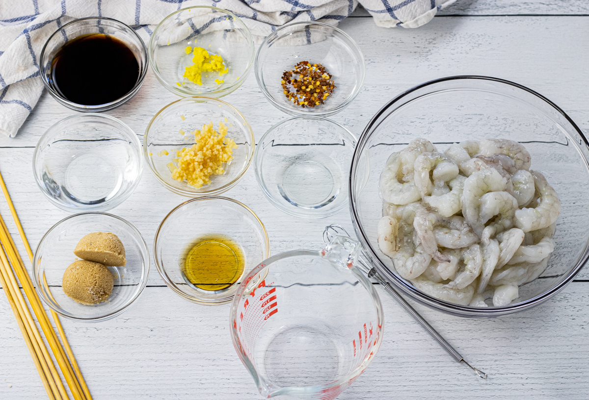 small, glass bowls of ingredients for teriyaki sauce and raw shrimp