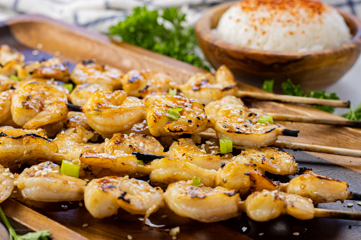 grilled shrimp on skewers on a wooden platter