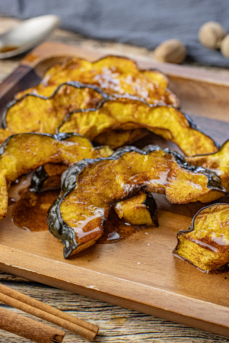 half moon slices of acorn squash cooked and drizzled with melted butter