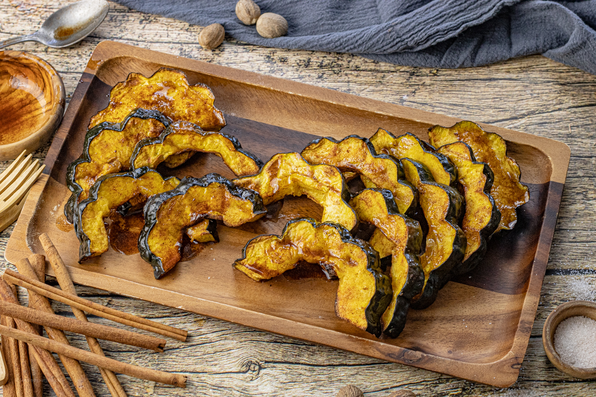 cooked slices of acorn squash on a wooden platter